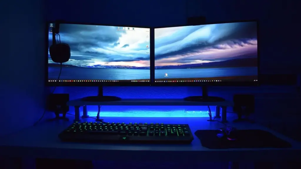 Zwei Monitore mit angeordneten Fenstern auf einem Schreibtisch