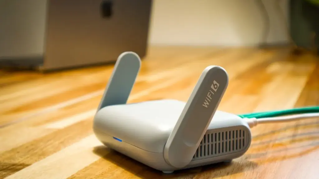WLAN-Router auf einem Holztisch vor einem Laptop